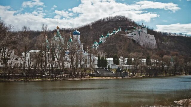 Orthodox church on a rock, autumn landscape and floating clouds