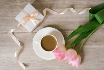 Pink spring tulips, a gift box and a cup of coffee. The concept of women's Day or mother's day. Flat lay. Spring Festival