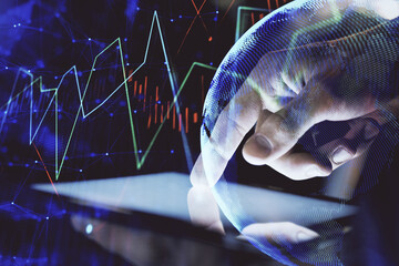 Double exposure of man's hands holding and using a digital device and forex graph drawing. Financial market concept.