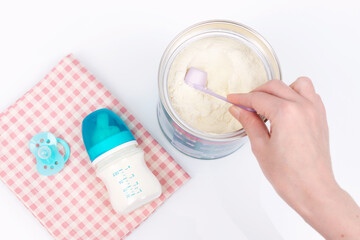 Woman's hand grabbing a scoop of powdered baby milk