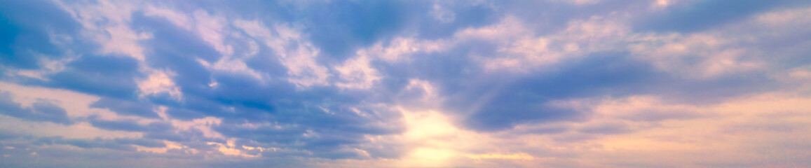 Panoramic sky with yellow Winter sun and Stratocumulus clouds. A panorama of the cold blue sunset...
