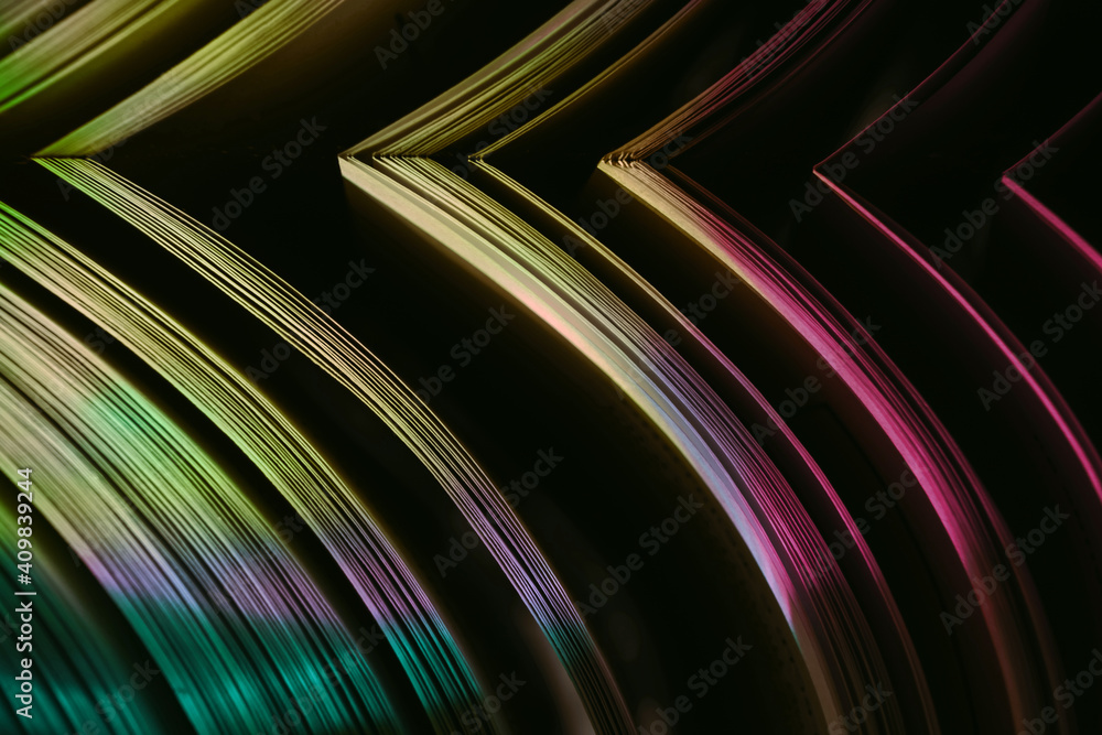 Fototapete Close up Beautiful book pages in the multi color light on a night. Background pattern for design. Macro photography view.