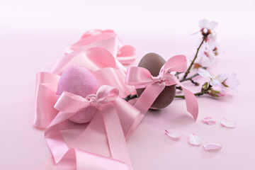 Easter eggs with pink ribbon and cherry blossoms