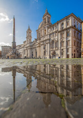 Obraz premium Rome, Italy - in Winter time, frequent rain showers create pools in which the wonderful Old Town of Rome reflect like in a mirror. Here in particular Piazza Navona