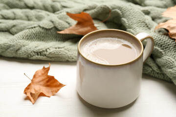 Composition with coffee and warm plaid on white wooden table, closeup