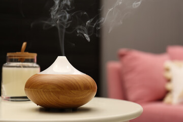 Aroma oil diffuser on table in room. Space for text