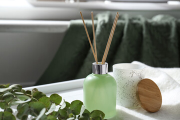 Reed air freshener and eucalyptus branches on tray indoors © New Africa