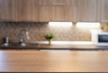 Fototapeta na wymiar blurred kitchen interior and wooden desk space home background