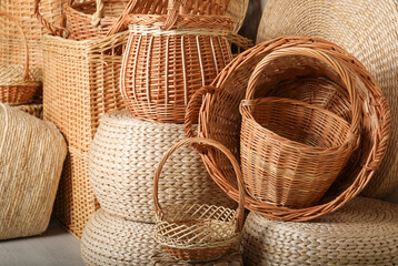 Many different wicker baskets made of natural material as background, closeup