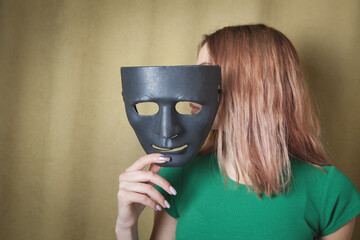 Young woman holding black mask. Fake, anonymous