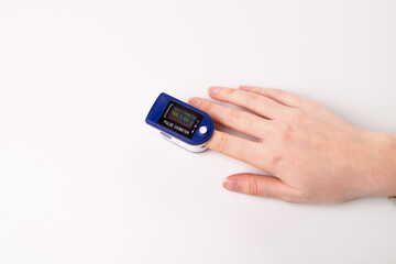 Close up of Finger and hand in an Oximeter Device. Pulse oximeter on white background. top view