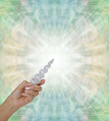 Crystal Healing with a Selenite Spiral Wand - hand holding beautiful carved selenite spiral wand in...