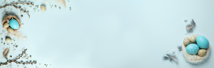 Flat lay composition with colorful Easter eggs on light blue background, space for text. Horizontal banner design