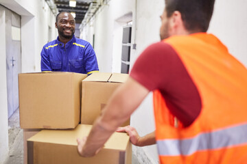 Lagerarbeiter transportieren Pakete auf Schubwagen