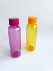 Colorful plastic travel bottles. Small containers for liquids like shower gel and shampoo. Face and body care products in compact size.