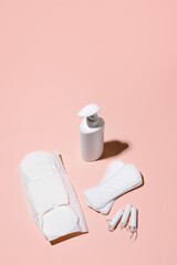 Girl, women intimate hygiene products - sanitary pads, daily pads, intimate liquid soap and tampon on pink background. Concept of monthly feminine routine menstruation critical days, hard shadow