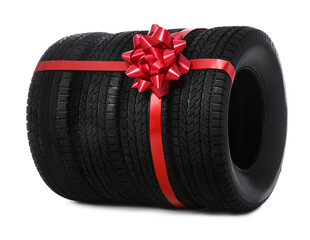 Winter tires with red ribbon on white background © New Africa