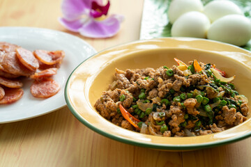 chopped pork in Thai chilli and basil in yellow ceramic plate.