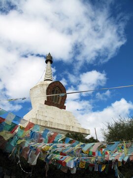 Pagoda surrounded by Tibetan talisman flags on a cloudy day.