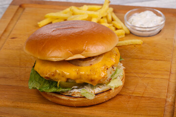 Homemade burger with fish, cheese and salad leaves