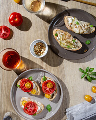Sandwiches on plates on the table, bright sun, hard shadows.