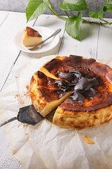 Cut basque burnt cheesecake with silver spatula at home kitchen