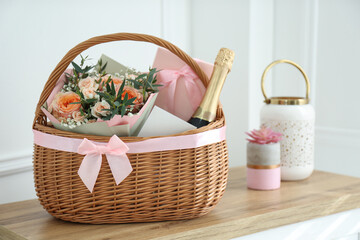 Fototapeta na wymiar Wicker basket with gifts on table indoors