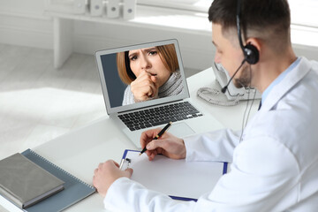 Hotline service. Doctor consulting patient online via laptop indoors