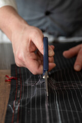 A tailor cutting a cloth according to the tradition of tailors. man Hands, Close Up and selective...