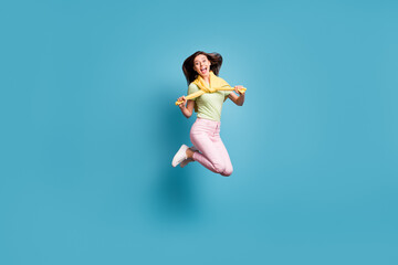 Full size photo of young happy smiling crazy excited girl jumping with jumper on shoulders isolated...