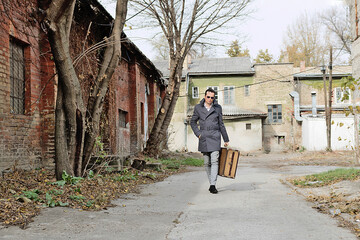 Full length of a man with suitcase walking through empty street.