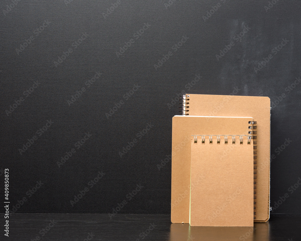 Poster closed notepad with brown sheets on black background