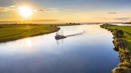 Aerial view of river with ship at sunset
