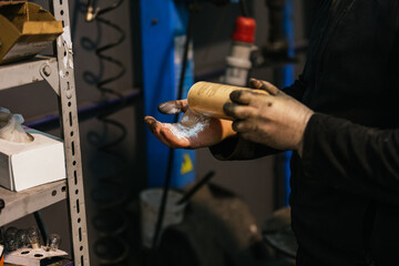 Mechanic washing his hands with talcum powder. Mechanics and cleaning concept.