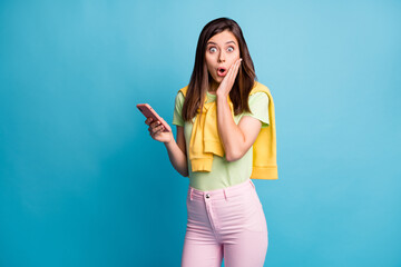 Portrait of attractive amazed girl using device browsing web news pout lips isolated over bright blue color background