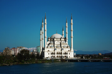 Naklejka premium Mosque with six minarets in Adana, Turkey. Mosque, river and bridge view together.