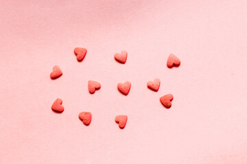 Sugar candy hearts on a pink background. Background for designers.