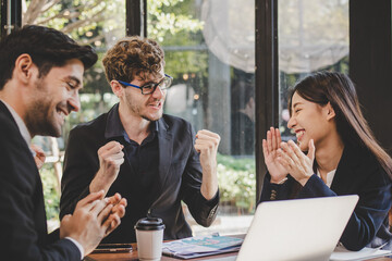 Cheer up,Smiling business people group,teamwork of young asian,caucasian having fun,happy in workplace after project is done,win while conference with partners on laptop.Celebrating success concept.