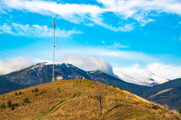 Telecommunication tower against the backdrop of an awesomely beautiful sky with blurry snow-white clouds
