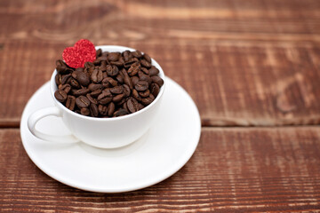 Coffee beans in a cup on a wooden background. Soft selective focus. Copy space.