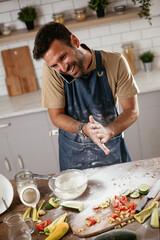 Happy man baking in the kitchen. Man making fresh pasta.