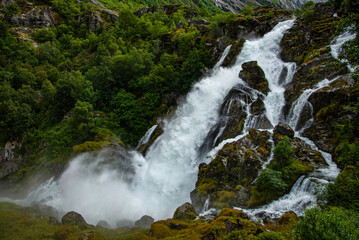 Naklejka na ściany i meble Kleivafossen waterfall, Briksdalselva river, Norway. The river is fed by the melting Briksdal Glacier (Briksdalsbreen).