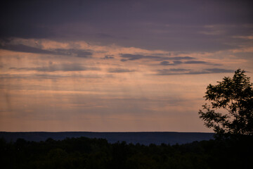 rain seen from afar at sunset. colored clouds on the horizon