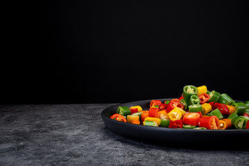 Pepper slices on black dull plate