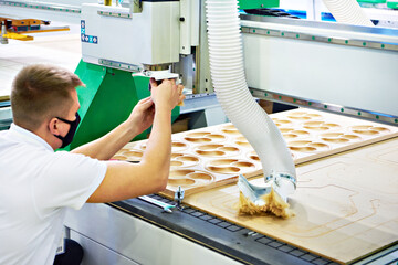 Worker on a CNC milling and engraving machine