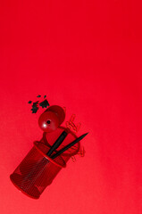 Top view of pen holder, pensil, pen, sharpener, pen shavings on the red background.Empty space