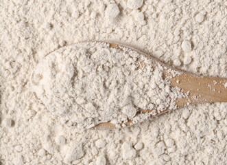 Rye flour with wooden spoon background and texture, top view