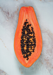 Ripe juicy half papaya cut on white marble  background.Tropical nature fruits summer concept.