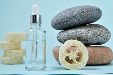 Fototapeta na wymiar Cosmetic serum in white dropper bottles on natural stone. Blue background, natural skincare products concept.