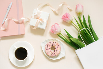 Tulips, gift box and coffee on a beige background. Flat lay. 8 March, International Women's Day. Valentine's Day. Blogger's workplace